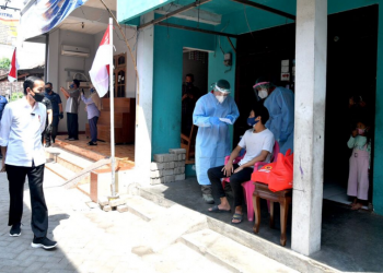 Presiden Joko Widodo meninjau program vaksinasi Covid-19 untuk masyarakat secara pintu ke pintu yang dilaksanakan di Gang Kampung Pesilat, Kecamatan Mejayan, Kabupaten Madiun, Jawa Timur, pada Kamis, 19 Agustus 2021.