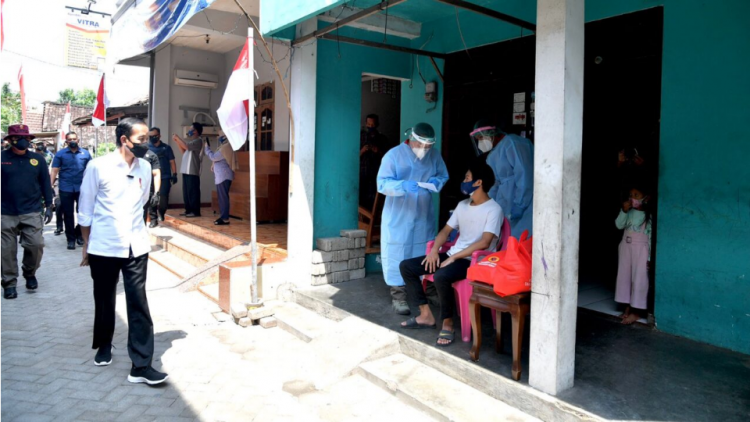 Presiden Joko Widodo meninjau program vaksinasi Covid-19 untuk masyarakat secara pintu ke pintu yang dilaksanakan di Gang Kampung Pesilat, Kecamatan Mejayan, Kabupaten Madiun, Jawa Timur, pada Kamis, 19 Agustus 2021.